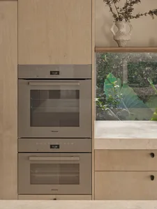 Kitchen with stainless steel ovens, wooden countertop, digital display, clocks, and a fishbowl