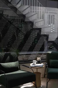 A wooden staircase with a metal railing, a chair, and a coffee cup on a nearby table in a calm and inviting atmosphere