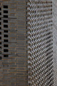 A brick wall with a unique pattern of bricks, made of stone, on a building's exterior