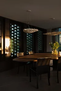 Cozy dining area with a wooden table and chairs, surrounded by large windows allowing natural light to fill the space