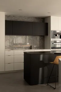 Modern kitchen with black cabinets, marble countertops, a large island, two ovens, and a sink
