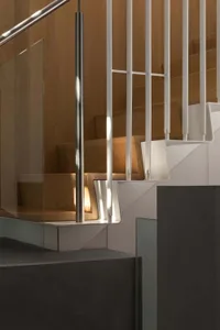 A daytime photo of a staircase with wooden steps, surrounded by a building's interior, with natural light and a warm atmosphere