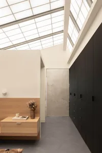 A modern study space with a wooden desk, two cabinets, and a vase on the desk, featuring a focus on functionality and simplicity