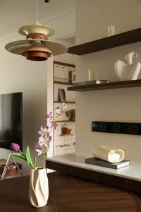 Cozy living space with a white table, potted plants, and decorative items, set against a neutral background