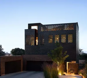 A modern house with a brick exterior, featuring a mix of materials and a sophisticated design, set in a suburban residential area