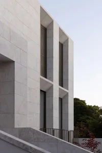 A rendered image of a building with a stone exterior and a large window allowing natural light into the interior, creating a bright and inviting atmosphere