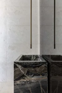 Bathroom with two black marble sinks, marble countertops, and a luxurious design