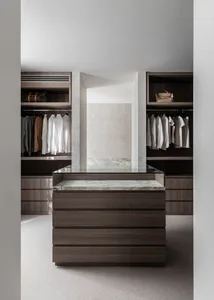 Well-lit walk-in closet with wooden floors, marble countertops, and numerous hanging clothes and handbags