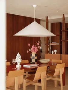 Dining area with a wooden table, three chairs, and a vase, set in a luxurious interior