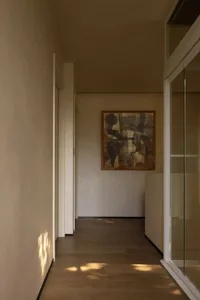 Empty hallway with white walls and wooden floors, giving a clean and minimalist appearance