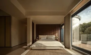 Cozy bedroom with a large bed on a hardwood floor, white bedding, and natural light from windows, decorated with vases