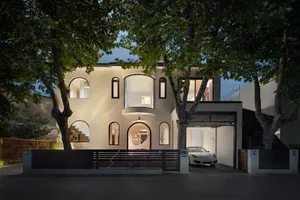 A well-lit, spacious modern home with a mix of wood and stone elements, surrounded by trees and featuring multiple windows for natural light