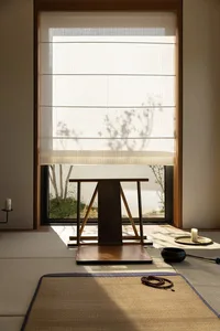A wooden table and chairs in a cozy room with natural light from a window