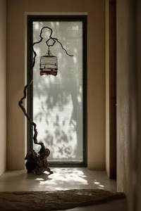 A tree branch transformed into a bird feeder in front of a sunny window, creating a peaceful atmosphere