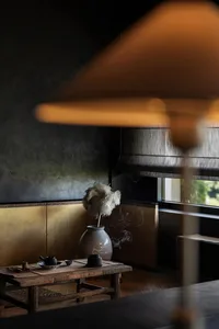 燈光柔和的客廳區域，配有燈具、花瓶與一碗灰燼，營造舒適放鬆或閱讀氛圍