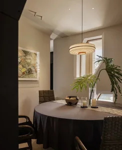 Elegant dining space with a round table surrounded by chairs, vases, and bottles, creating a comfortable and inviting atmosphere