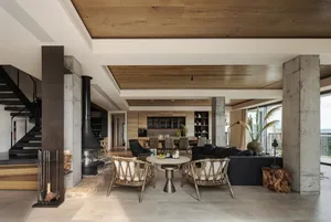 Warm and inviting open concept living area with a large fireplace, wooden floors and walls, and various decorative elements