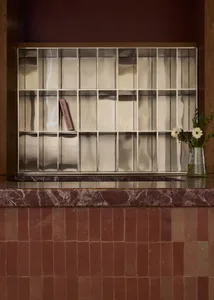 A marble countertop with a pink paperback book placed on it, set in a room with a wooden countertop and an elegant atmosphere