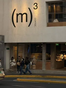 A modern coffee shop with a large window and a group of people walking outside in a city environment