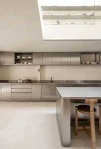 Modern kitchen with a stainless steel countertop and wooden table, featuring a sleek and inviting atmosphere with bright lighting