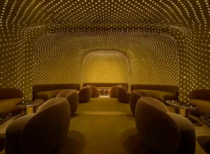A warm and inviting room with a yellow ceiling and walls, featuring various seating options and a comfortable atmosphere
