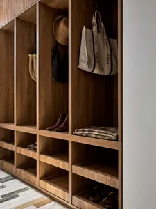 A storage room with wooden shelves filled with personal belongings, including a hat and a handbag, giving a warm and natural feel
