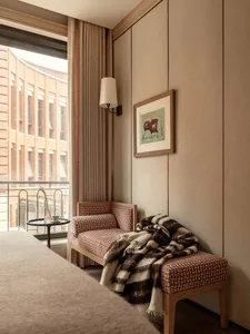 Cozy living room with a couch and chair, well-lit by natural light from a window, creating a warm and inviting atmosphere