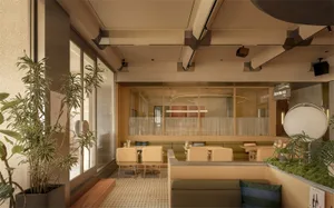 A modern restaurant with a large dining area featuring multiple tables, chairs, couches, and dining tables, well-lit with natural light and potted plants