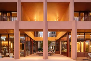 A modern office space with a large atrium and skylight, filled with furniture and natural light
