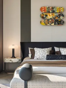 Cozy bedroom with a striped wall, a bed, a chair, and a skateboard painting on the wall