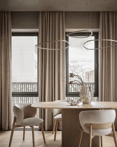 A well-lit living room with a dining table, chairs, and a vase, featuring a mix of wood and glass materials in a modern and inviting space