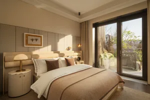 Cozy bedroom with a brown blanket-covered bed, a chair near the window, and natural light from the window