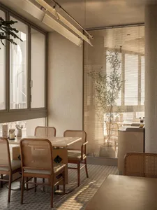 Cozy modern restaurant interior with wooden furniture, dim lighting, and decorative items on tables and countertops