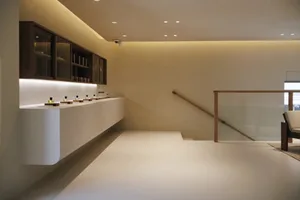 2D floor plan of a minimalist kitchen with a white countertop and a wooden staircase, featuring a sink and a staircase leading to another floor
