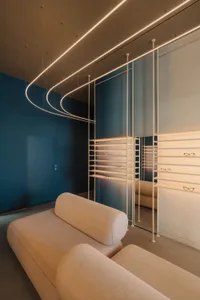 Comfortable living space with a blue accent wall, a couch, a chair, and a mirror, well-lit and inviting