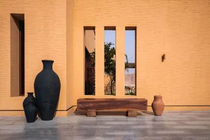 A warm and inviting living space with a wooden bench and vases, surrounded by natural light from a window