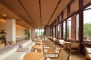 Cozy modern restaurant with a brown and tan color scheme, semi-circular seating, and potted plants, dim lighting