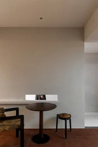 低調的餐廳餐桌區,有棕色的木桌,一面鏡子,兩把椅子,營造出溫馨的氣氛