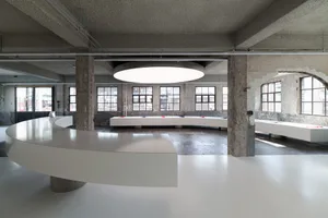 White and black floor plan of a modern lobby-dining space with a central round table and various furniture pieces