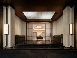 A modern lobby with a marble floor, decorated with various potted plants of different sizes, creating a visually appealing and inviting atmosphere