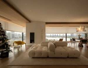 Cozy modern living space with a white couch, fireplace, dining table, and rug, well-lit with natural light from windows