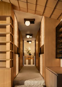 Cozy hallway with wooden floor, shelves, and cabinets, dimly lit for a warm atmosphere