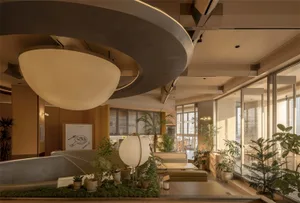 Cozy living room with a circular light fixture, a couch, dining table, and potted plants, featuring soft and warm lighting