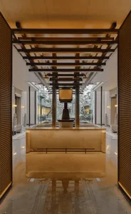 Modern lobby with a white marble countertop, chairs, and natural light from a large window
