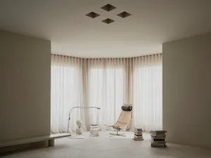 A modern living room with a white chair, bench, and bookshelf, filled with books, in a well-lit space with natural sunlight