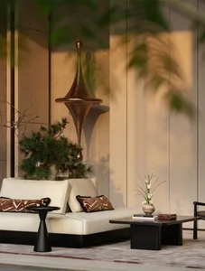 A well-lit living room with a white couch and chair on a hardwood floor, featuring a potted plant and a comfortable atmosphere