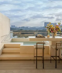 A modern living room with a large window, a bathtub, and a dining table, featuring wood and glass materials and natural lighting