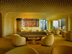 Cozy modern lounge area with a bar, multiple seating options, and a warm ambiance created by natural and artificial light sources