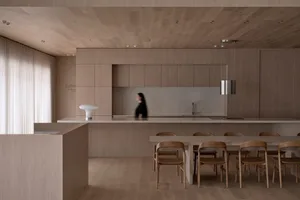 Warm and inviting kitchen with wooden floors and cabinets, a dining table, and soft diffused lighting
