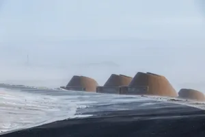 A row of small wooden cabins in a snowy landscape, creating a sense of community and shared living space